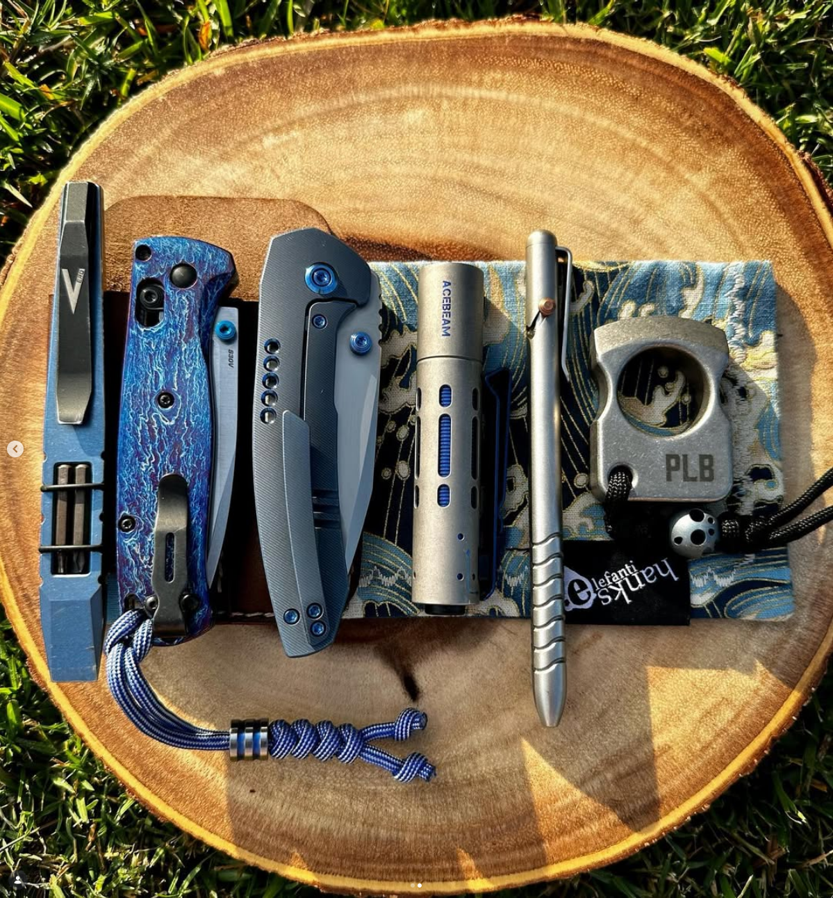 ELE Survival blue titanium EDC loadout on wood slice